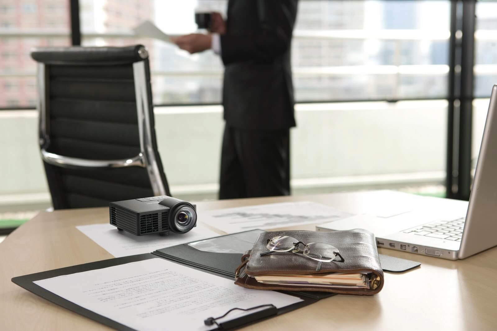 ricoh projecteur press posé sur un bureau. On constate qu'il est aussi grand qu'une paire de lunette